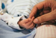 person holding baby's index finger
